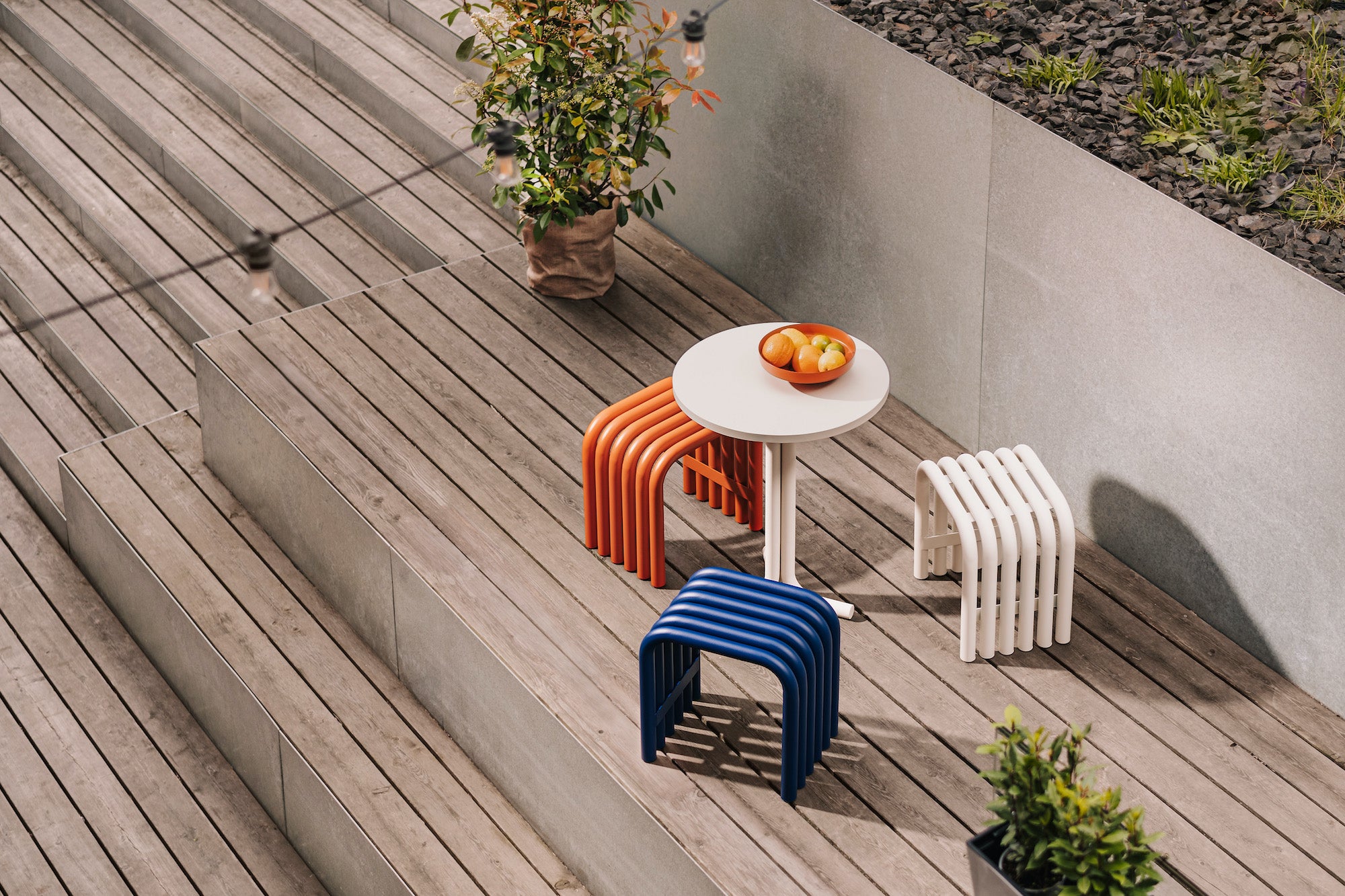 balcony-garden beige outdoor tables blue bowls orange stools 