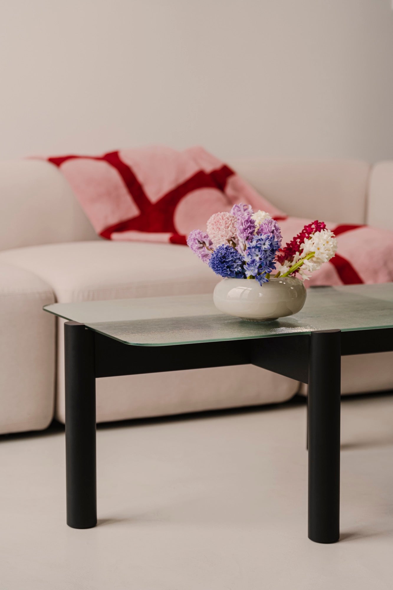 schwarzer Couchtisch Wohnzimmer beige rosa sofas Überwürfe 